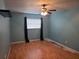 Bedroom featuring blue walls, ceiling fan, one window with dark curtains, and light flooring at 4506 Se 7Th Pl, Ocala, FL 34471