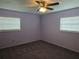 A standard bedroom with neutral paint, ceiling fan, two windows, and wall-to-wall carpeting at 4506 Se 7Th Pl, Ocala, FL 34471