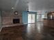 Open living room features a brick fireplace, ceiling fan, and sliding glass doors at 4506 Se 7Th Pl, Ocala, FL 34471
