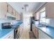 Galley kitchen featuring blonde wood cabinets, stainless steel appliances, and blue countertops at 14791 Sw 29Th Avenue Rd, Ocala, FL 34473