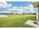 Spacious backyard with lush green grass and a tranquil lake view in a serene setting at 3387 Tawny Grove Pl, Lakeland, FL 33811