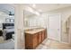 Bathroom with a double sink vanity and granite countertops is visible through the bedroom doorway at 3387 Tawny Grove Pl, Lakeland, FL 33811