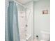 Bright bathroom with a shower-tub combo, featuring a blue shower curtain and a white tiled wall at 3387 Tawny Grove Pl, Lakeland, FL 33811