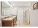 Bathroom features a double sink vanity with granite countertops, tile flooring, and a shower with curtain at 3387 Tawny Grove Pl, Lakeland, FL 33811