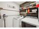 Well-organized laundry room with a washer, dryer, shelves, storage, and decorative accents at 3387 Tawny Grove Pl, Lakeland, FL 33811