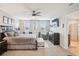 A cozy and well-lit main bedroom featuring a ceiling fan, soft carpet, and an ensuite bathroom at 3387 Tawny Grove Pl, Lakeland, FL 33811