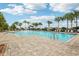 Resort-style pool area with palm trees, sun loungers, and splash pad in a beautiful community at 3387 Tawny Grove Pl, Lakeland, FL 33811
