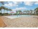 Community pool featuring sun loungers, palm trees, and a splash pad under a sunny sky at 3387 Tawny Grove Pl, Lakeland, FL 33811