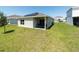 Backyard view of the home with solar panels and covered patio area at 726 Eagle Landing Blvd, Winter Haven, FL 33880