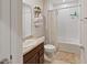 Functional bathroom featuring a shower-tub combo, storage shelves, and neutral decor at 726 Eagle Landing Blvd, Winter Haven, FL 33880
