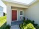 Charming front porch with a bright red door and decorative landscaping at 726 Eagle Landing Blvd, Winter Haven, FL 33880