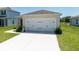 Two car garage with driveway and manicured lawn at 726 Eagle Landing Blvd, Winter Haven, FL 33880