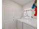 Efficient laundry room featuring modern appliances, utility storage, and easy access via an interior door at 726 Eagle Landing Blvd, Winter Haven, FL 33880