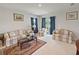 Well-lit living room features neutral furniture, large windows, and a patterned area rug at 726 Eagle Landing Blvd, Winter Haven, FL 33880