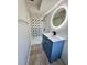 Renovated bathroom with blue vanity and unique illuminated oval mirror at 3465 Peacock Ln, Mulberry, FL 33860