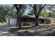 This home features a light grey garage, and dark siding with neutral trim and brick accents at 3465 Peacock Ln, Mulberry, FL 33860