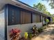 A close up view of a well maintained home exterior with a brick foundation and dark siding at 3465 Peacock Ln, Mulberry, FL 33860