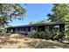 A lovely home features a dark exterior, well-manicured landscaping, and plenty of curb appeal at 3465 Peacock Ln, Mulberry, FL 33860