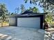 Exterior view of a spacious grey garage with a large door at 3465 Peacock Ln, Mulberry, FL 33860