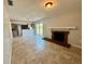 Open living room with tiled flooring, brick fireplace, and sliding glass doors at 3465 Peacock Ln, Mulberry, FL 33860