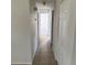 Hallway featuring tiled floors, white walls, and multiple doorways leading to different rooms within the home at 3640 Chart Prine Rd, Lakeland, FL 33810