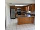 Well-lit kitchen features tile flooring, stainless steel appliances, a breakfast bar, and wooden cabinets at 3640 Chart Prine Rd, Lakeland, FL 33810
