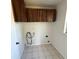 Functional laundry room with tiled floors, upper cabinets, and hookups for washer and dryer at 3640 Chart Prine Rd, Lakeland, FL 33810
