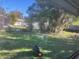 View of backyard featuring lush green grass and mature trees at 4707 Melody Ln, Lakeland, FL 33805