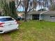 Charming home exterior with a well-maintained lawn, complemented by mature trees and a parked car at 4707 Melody Ln, Lakeland, FL 33805