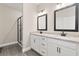 Bathroom featuring double vanity with granite countertops and a glass-enclosed shower at 7700 Somersworth Dr, Kissimmee, FL 34747