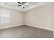 Bright bedroom featuring hardwood floors, neutral walls, ceiling fan and a tray ceiling at 7700 Somersworth Dr, Kissimmee, FL 34747