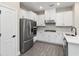 Modern white kitchen featuring stainless steel appliances, tile backsplash, and sleek countertops at 7700 Somersworth Dr, Kissimmee, FL 34747