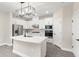 Modern white kitchen with stainless steel appliances, an island, and stylish lighting at 7733 Somersworth Dr, Kissimmee, FL 34747