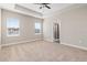 Spacious bedroom featuring a tray ceiling, plush carpet, and access to the ensuite bathroom at 7733 Somersworth Dr, Kissimmee, FL 34747