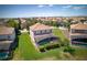 Aerial perspective showcasing a backyard featuring a screened-in pool, lush green lawn, and surrounding neighborhood at 1401 Wexford Way, Davenport, FL 33896