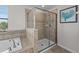 Corner view of the bathroom showing a tiled shower stall with glass doors, and a jetted tub at 1401 Wexford Way, Davenport, FL 33896