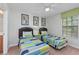 Twin bedroom with two beds featuring bright, geometric patterned bedding and a green accent dresser at 1401 Wexford Way, Davenport, FL 33896