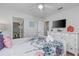 Bedroom with floral bedding, large dresser with a TV and attached bathroom and closet at 1401 Wexford Way, Davenport, FL 33896