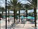 A Gathering-friendly community pool area with palm trees, loungers, and umbrellas for relaxation at 1401 Wexford Way, Davenport, FL 33896