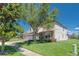 Two-story home featuring a tile roof, stone accents, a two-car garage, and a lush front yard with landscaping at 1401 Wexford Way, Davenport, FL 33896