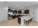 Modern kitchen with dark cabinetry, stainless steel appliances, and a breakfast bar with seating at 1401 Wexford Way, Davenport, FL 33896