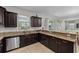 Spacious kitchen featuring granite countertops, dark cabinets, and stainless steel appliances with open floor plan at 1401 Wexford Way, Davenport, FL 33896