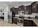Functional kitchen layout with dark wood cabinets, stainless appliances, and easy access to dining area at 1401 Wexford Way, Davenport, FL 33896