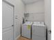 Functional laundry room with washer, dryer, and convenient overhead shelving for storage needs at 1401 Wexford Way, Davenport, FL 33896