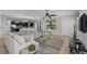 Spacious living room features a sectional sofa, glass coffee table, large windows, and an open layout to the kitchen at 1401 Wexford Way, Davenport, FL 33896