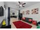 Comfortable living room with a large window, a red rug, a black futon and a view of the kitchen at 1401 Wexford Way, Davenport, FL 33896
