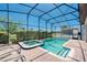Beautiful screened pool with a connecting spa, patio, and lush landscaping at 1401 Wexford Way, Davenport, FL 33896