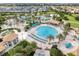 Aerial view of a large community pool with palm trees, cabanas, and lounge chairs in a well-maintained community at 1401 Wexford Way, Davenport, FL 33896