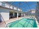 Screened pool with a spa, brick patio, and outdoor dining under a covered patio in a private backyard at 1401 Wexford Way, Davenport, FL 33896
