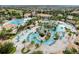 Aerial view of an amazing community pool area featuring a lazy river, beach entry, and tropical landscaping at 1401 Wexford Way, Davenport, FL 33896